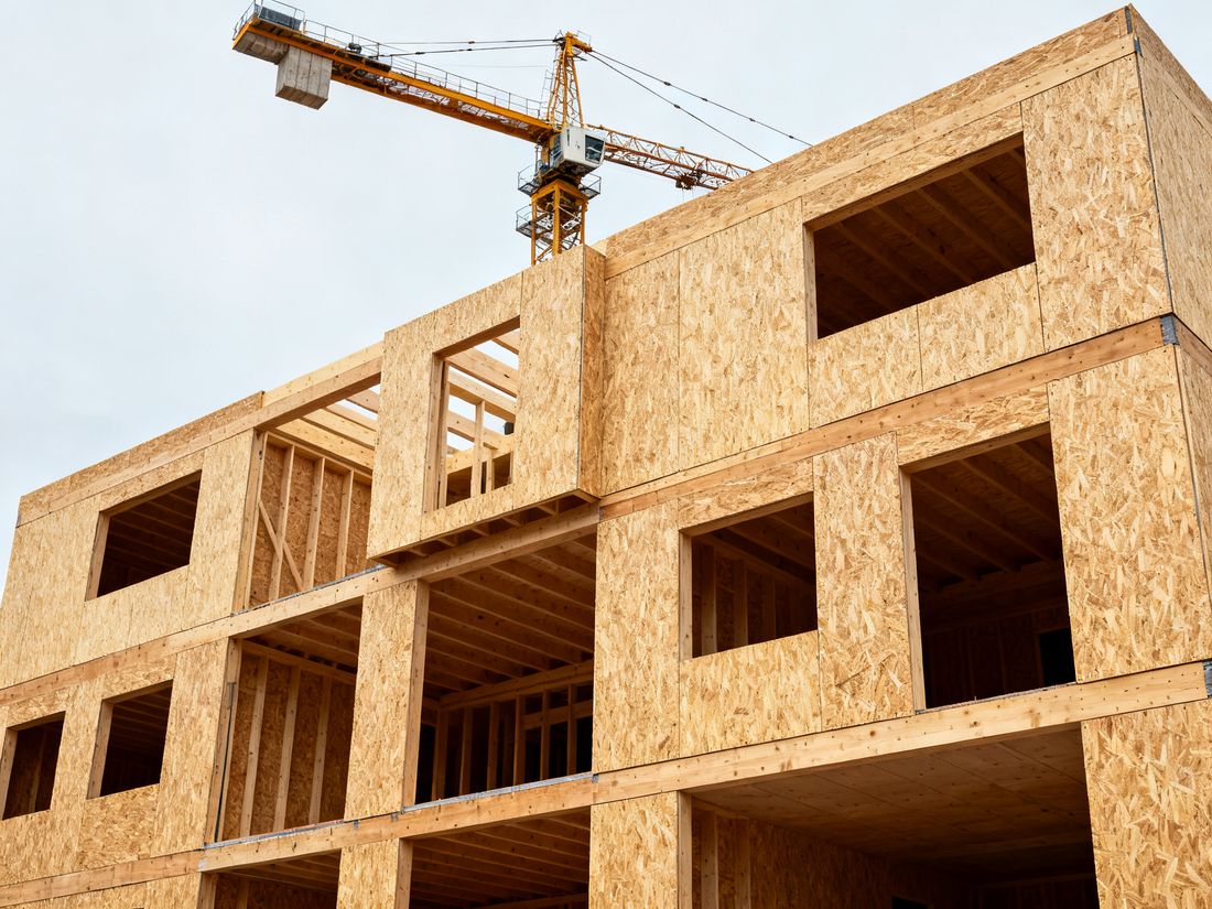 Mehrgeschossiges Holzgebäude im Bau mit sichtbaren Massivholzelementen
