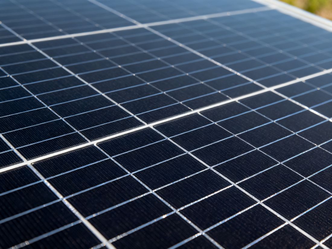 Nahaufnahme der dunklen Zellen eines monokristallinen Solarmoduls